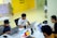 man in white polo shirt sitting on chair using macbook