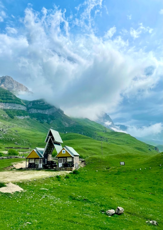 green and brown house near green mountains under white clouds during daytime in Laza Azerbaijan