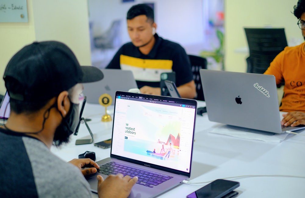 man in gray jacket using macbook pro