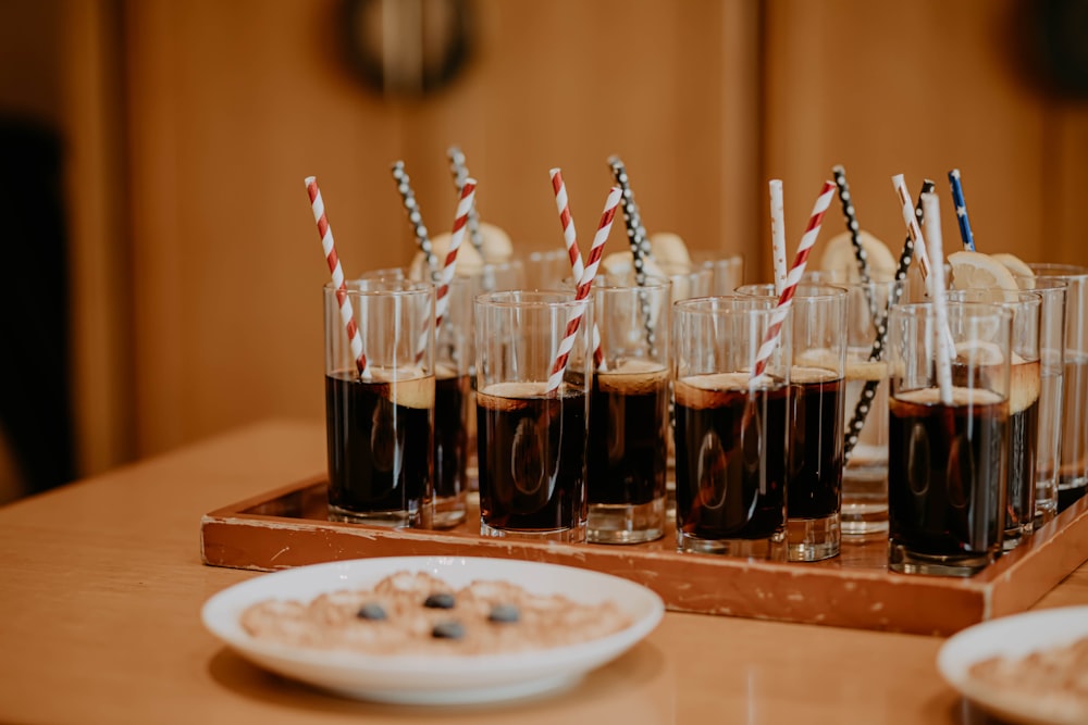 clear drinking glass with black liquid on brown wooden table