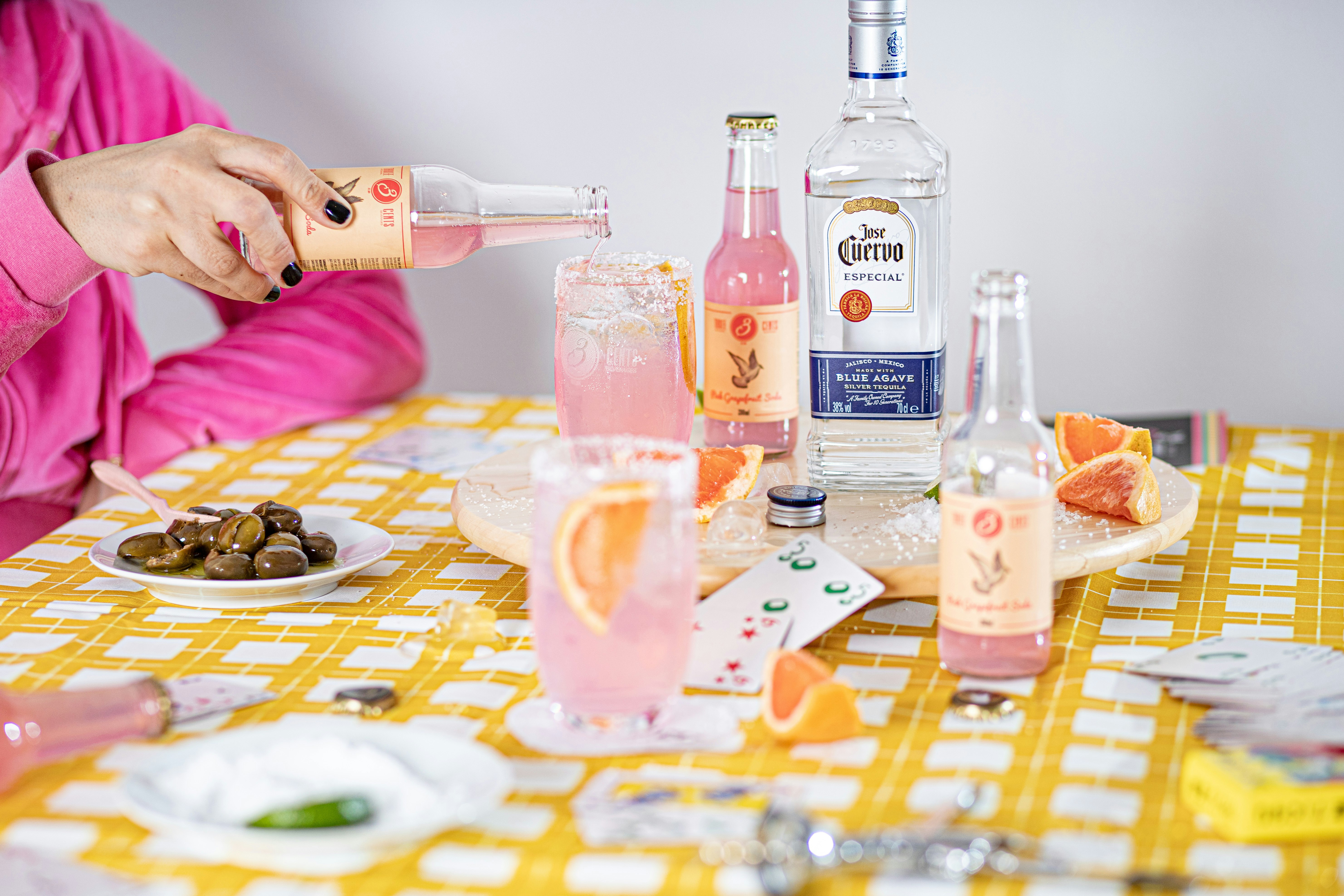 woman in pink long sleeve shirt holding clear glass bottle