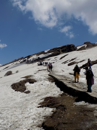 people walking on snow covered ground under blue sky during daytime