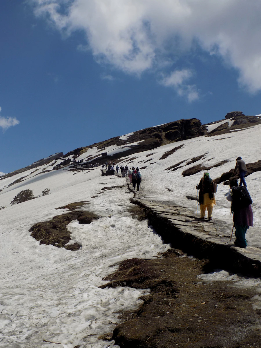 A small group trekking across snow towards a summit