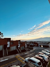Modern residential plots with clear boundaries and scenic mountain backdrop under a bright blue sky.