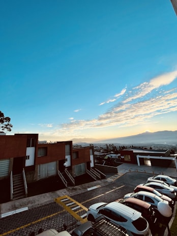 Modern residential plots with clear boundaries and scenic mountain backdrop under a bright blue sky.