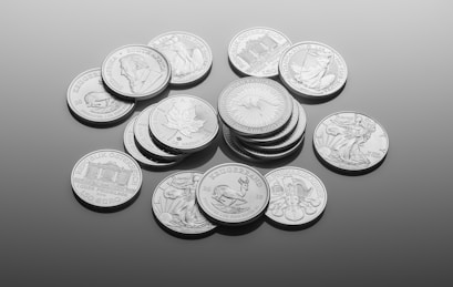 silver round coins on white surface