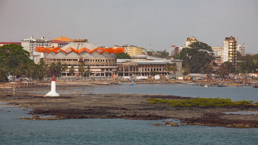 edificio in cemento bianco e marrone vicino allo specchio d'acqua durante il giorno