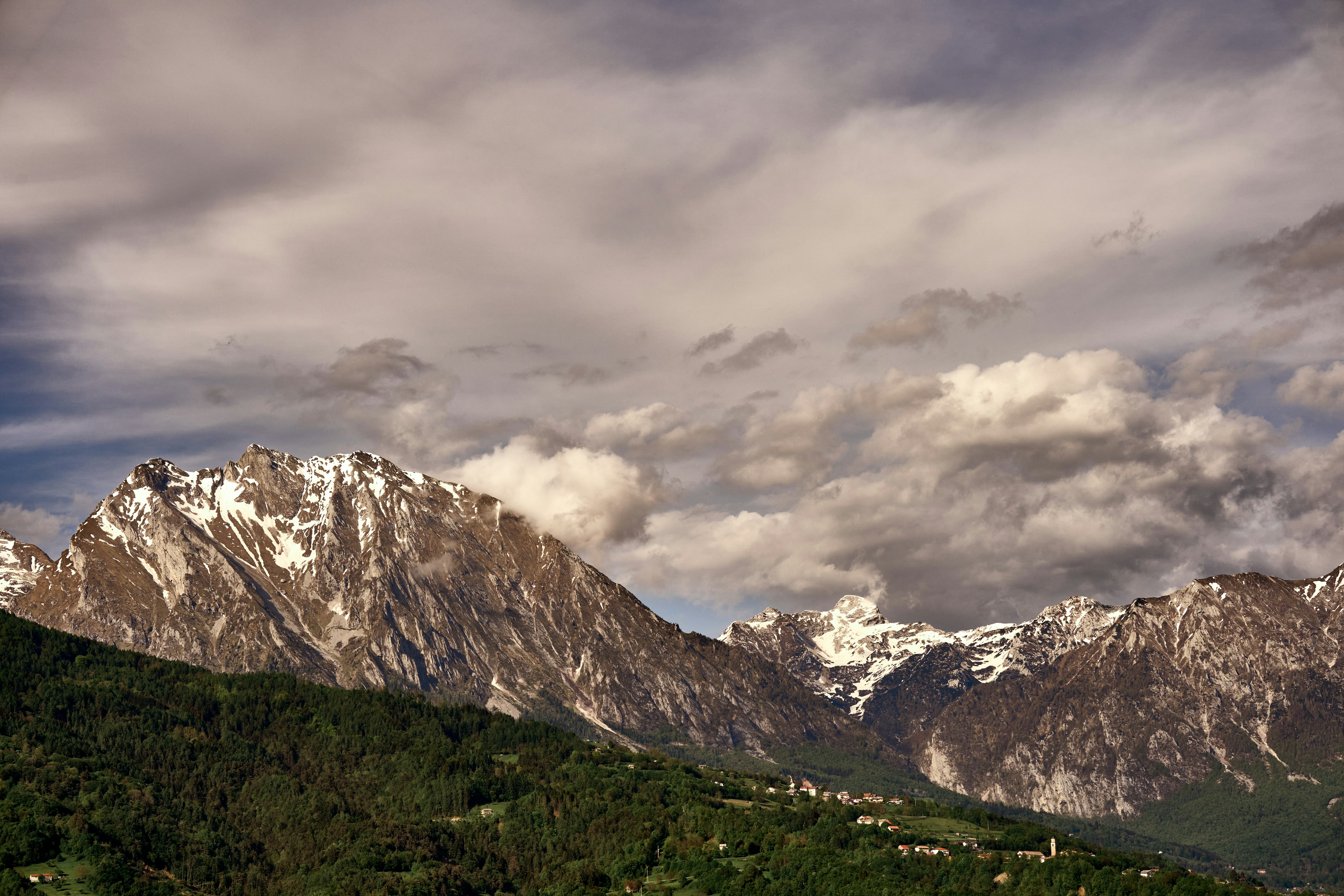 montagna innevata sotto il cielo nuvoloso durante il giorno