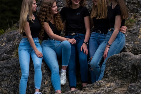 3 women sitting on rock