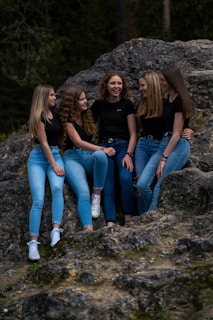 3 women sitting on rock