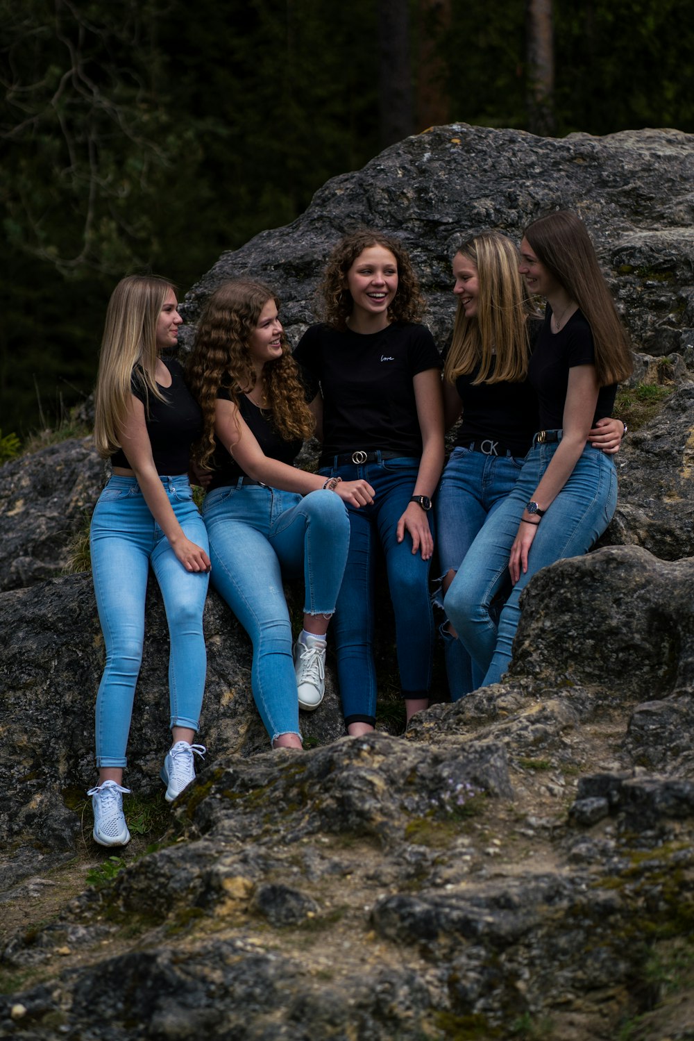 3 women sitting on rock