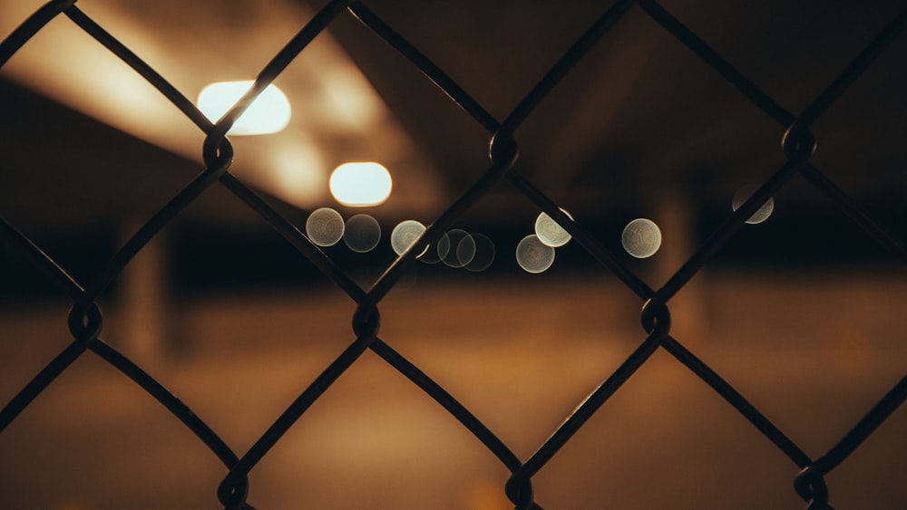 bokeh photography of black metal fence