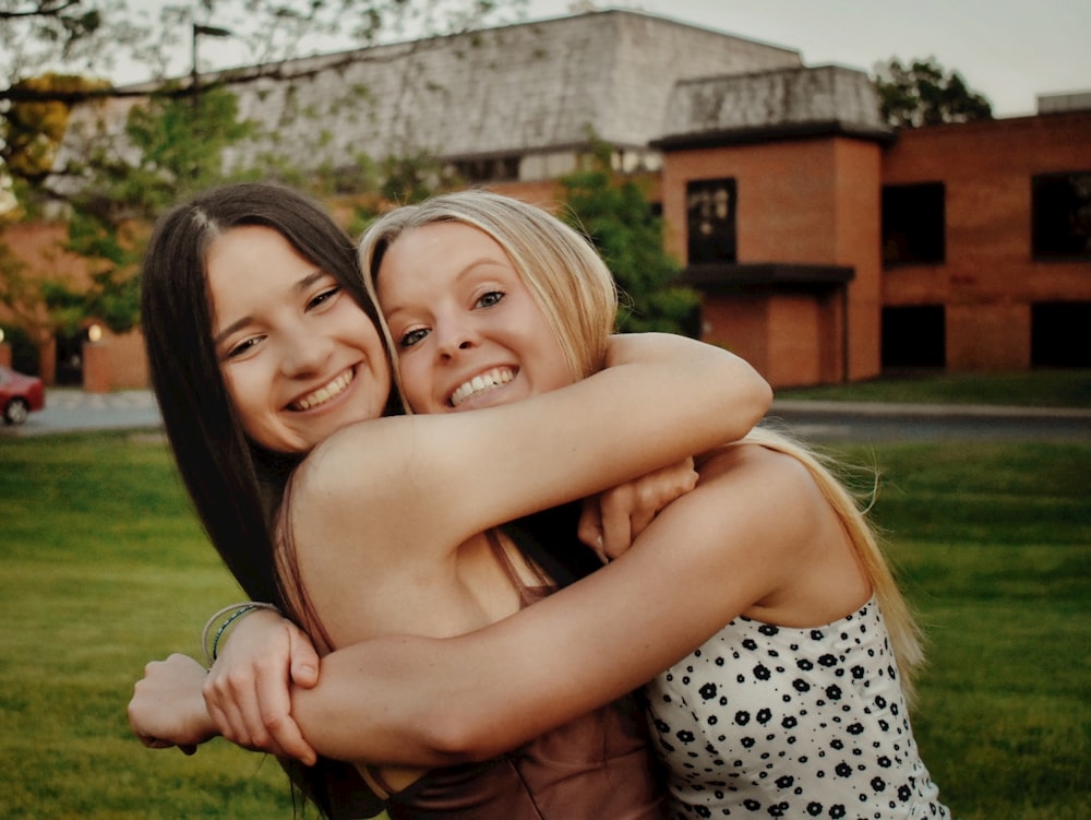 woman in white and black polka dot tank top hugging girl in white and black polka