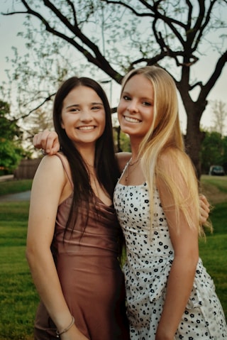 2 women in black and white polka dot tank top standing on green grass field during