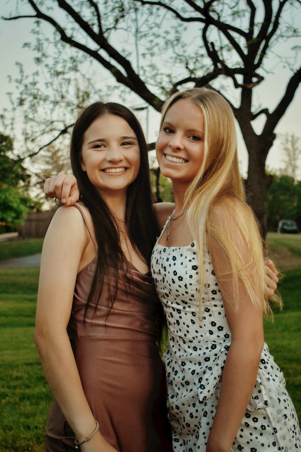 2 women in black and white polka dot tank top standing on green grass field during