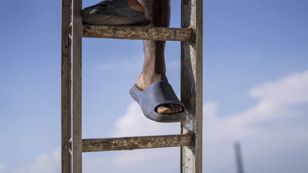 blue and brown boots on brown wooden ladder
