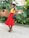 A joyful woman in a stylish dress posing outdoors.