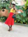 A joyful woman wearing a colorful African Ankara dress, smiling confidently outdoors.