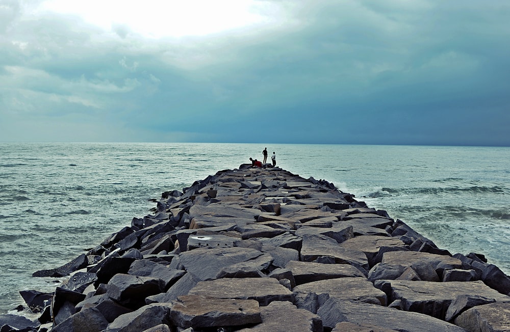 person in white shirt standing on gray concrete dock during daytime