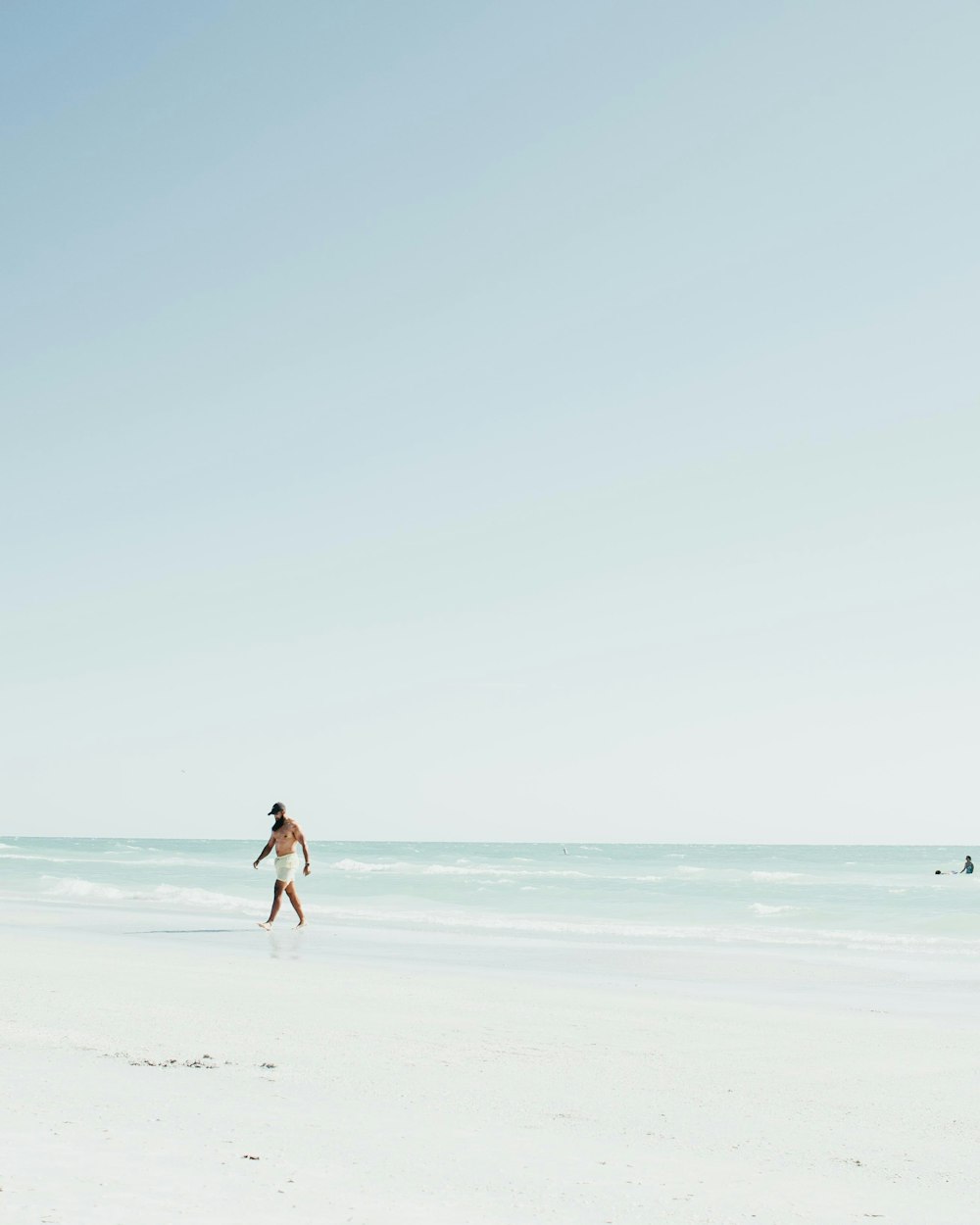 man and woman walking on beach during daytime