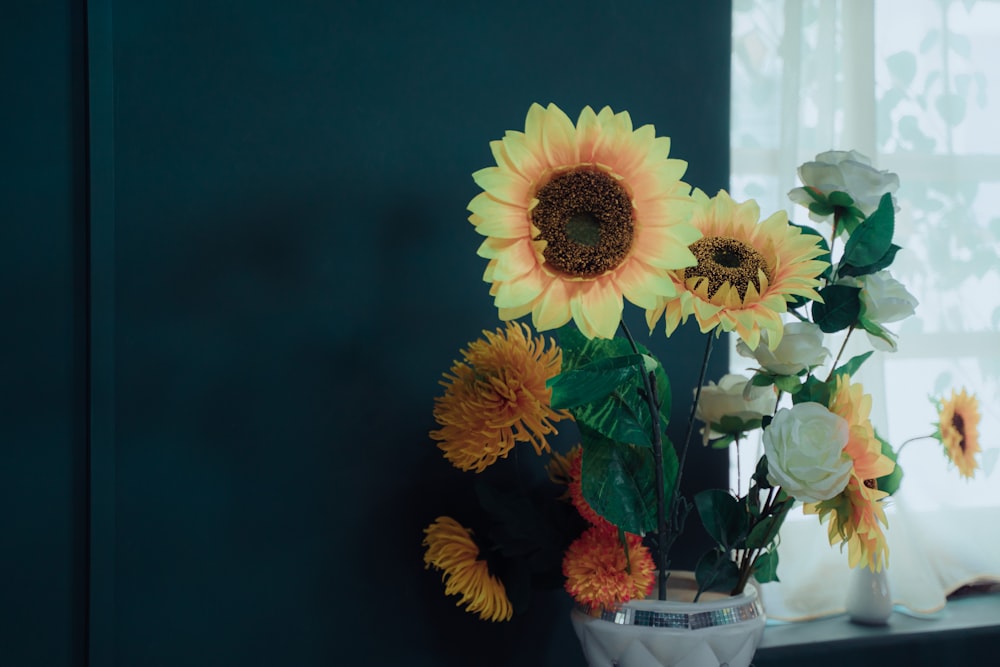 yellow and white flowers in clear glass vase