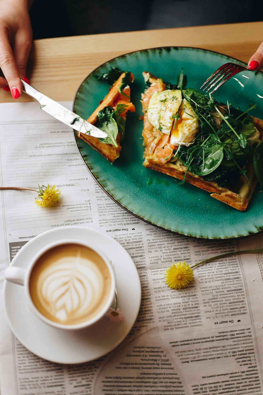 white ceramic mug with coffee beside green and yellow ceramic plate with food