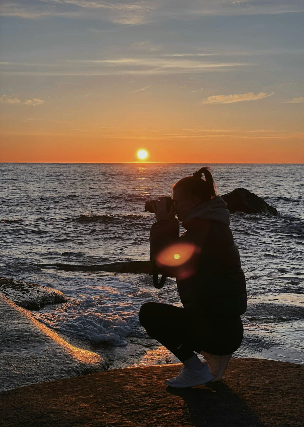 Silhouette von Mann und Frau, die sich während des Sonnenuntergangs am Strand küssen
