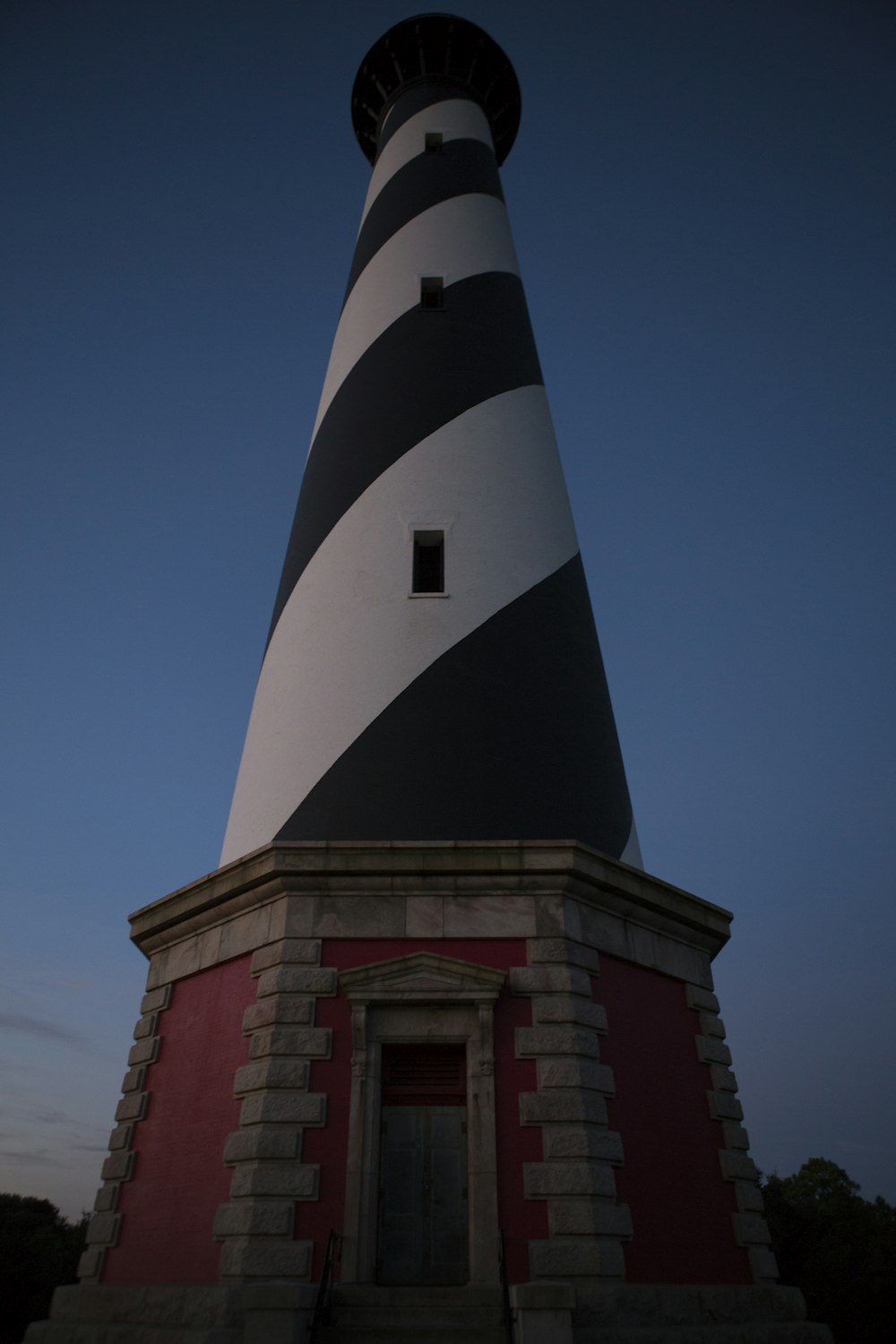 red and white concrete lighthouse under blue sky during daytime