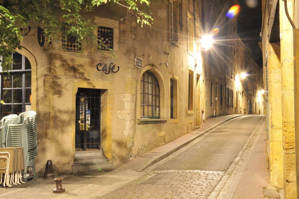 empty street in between of concrete buildings during night time