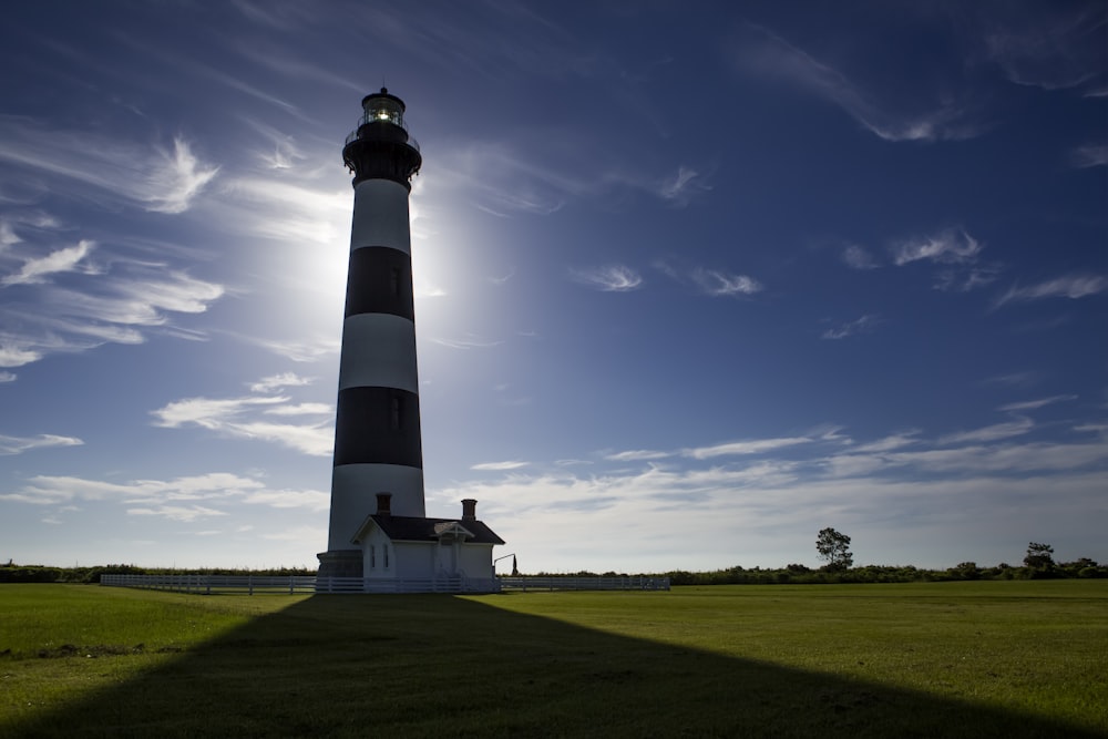 white and black lighthouse under blue sky during daytime