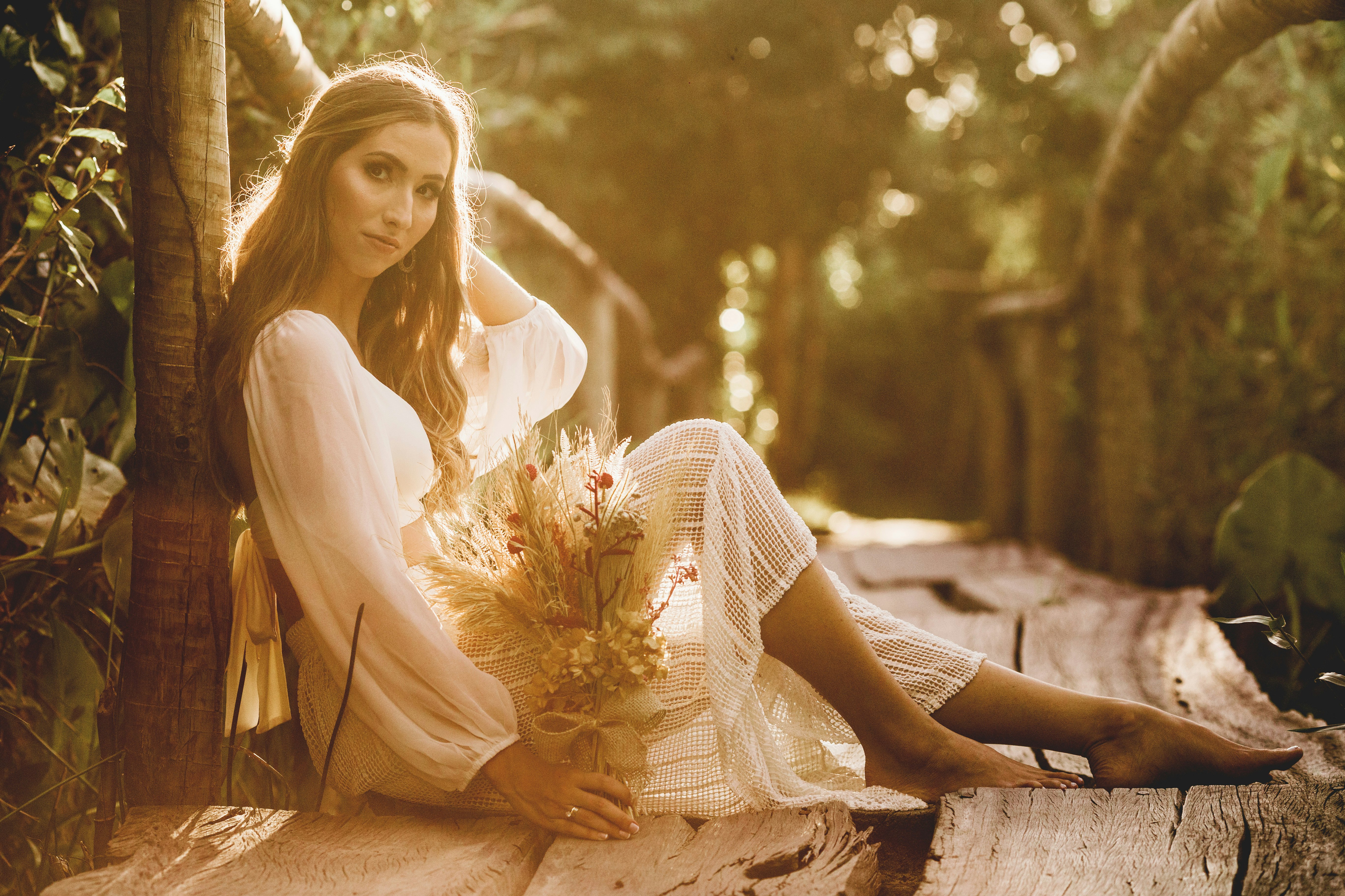 woman in white dress sitting on brown wooden bench