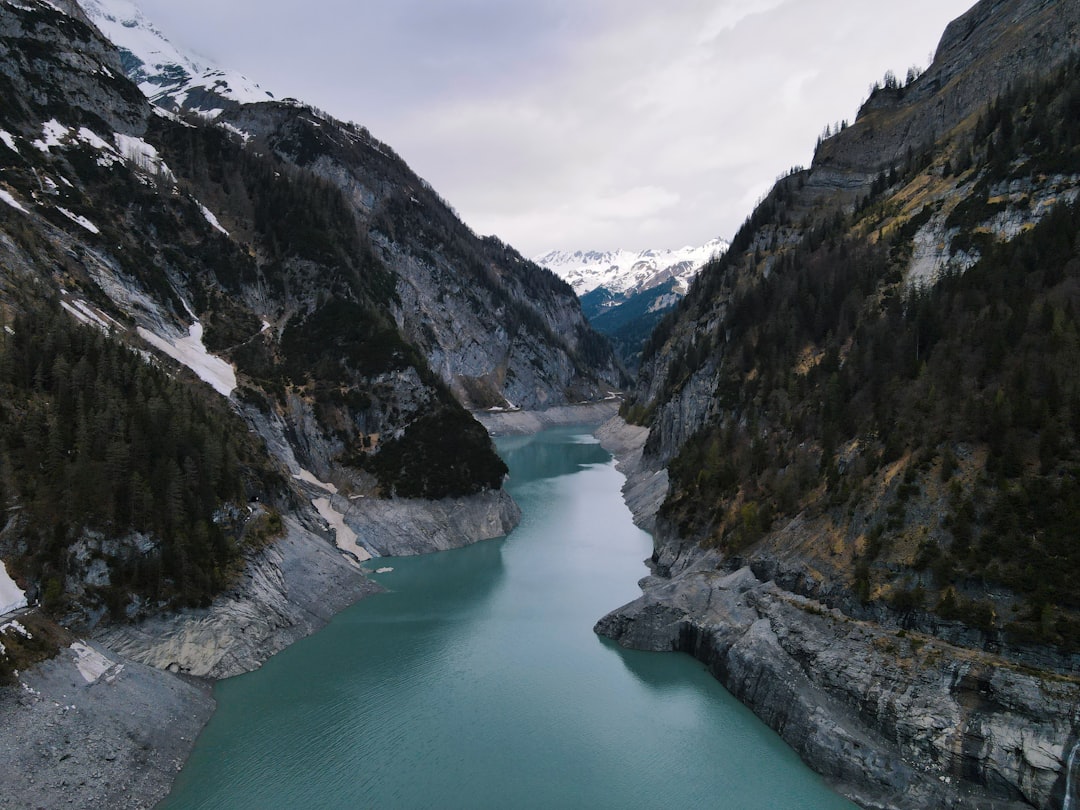 lake between mountains under cloudy sky during daytime