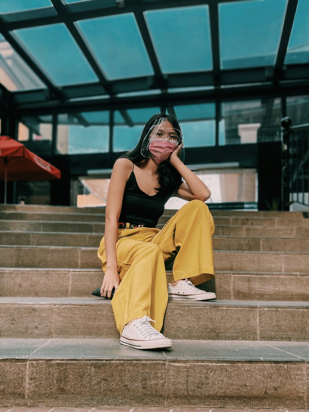 woman in yellow sleeveless dress sitting on concrete stairs