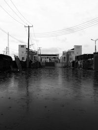 grayscale photo of buildings near body of water