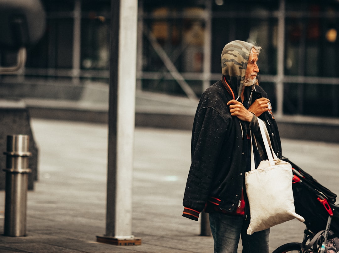 woman in black coat holding white tote bag
