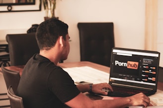man in black t-shirt using black laptop computer