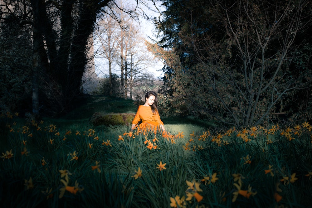 woman in yellow dress sitting on green grass field near river during daytime