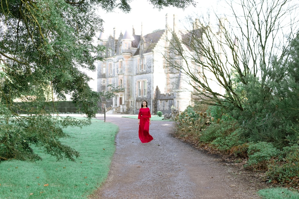 woman in red dress walking on pathway