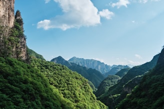 green mountains under blue sky and white clouds during daytime