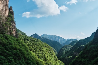 green mountains under blue sky and white clouds during daytime