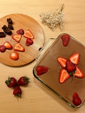 Close-up of a rich chocolate avocado mousse topped with fresh berries on a rustic wooden table.