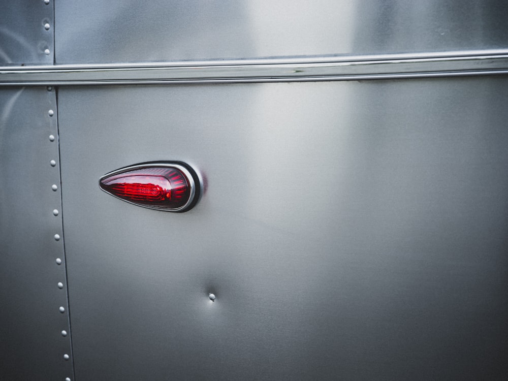 silver car with red and silver door handle