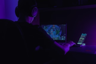 A person using a smartphone with headphones, engaging in an audio RPG game.