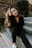 woman in black long sleeve shirt and blue denim jeans sitting on gray concrete stairs