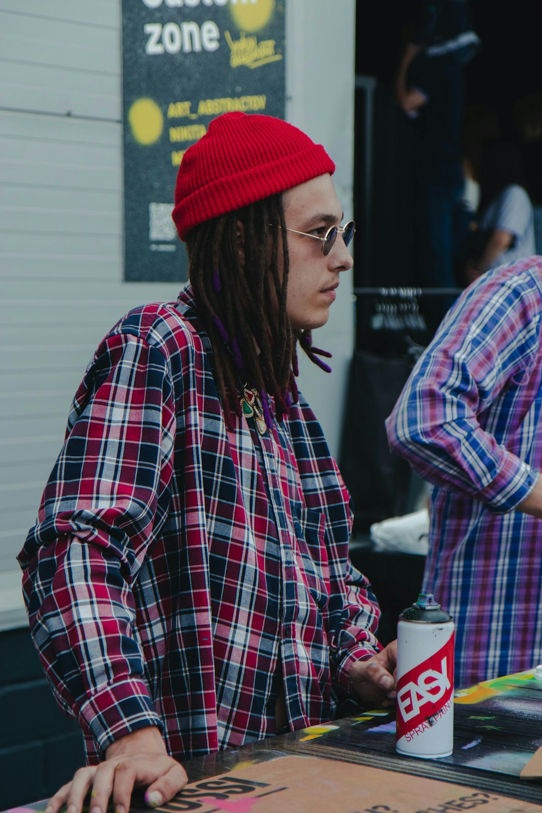 woman in red knit cap and plaid dress shirt
