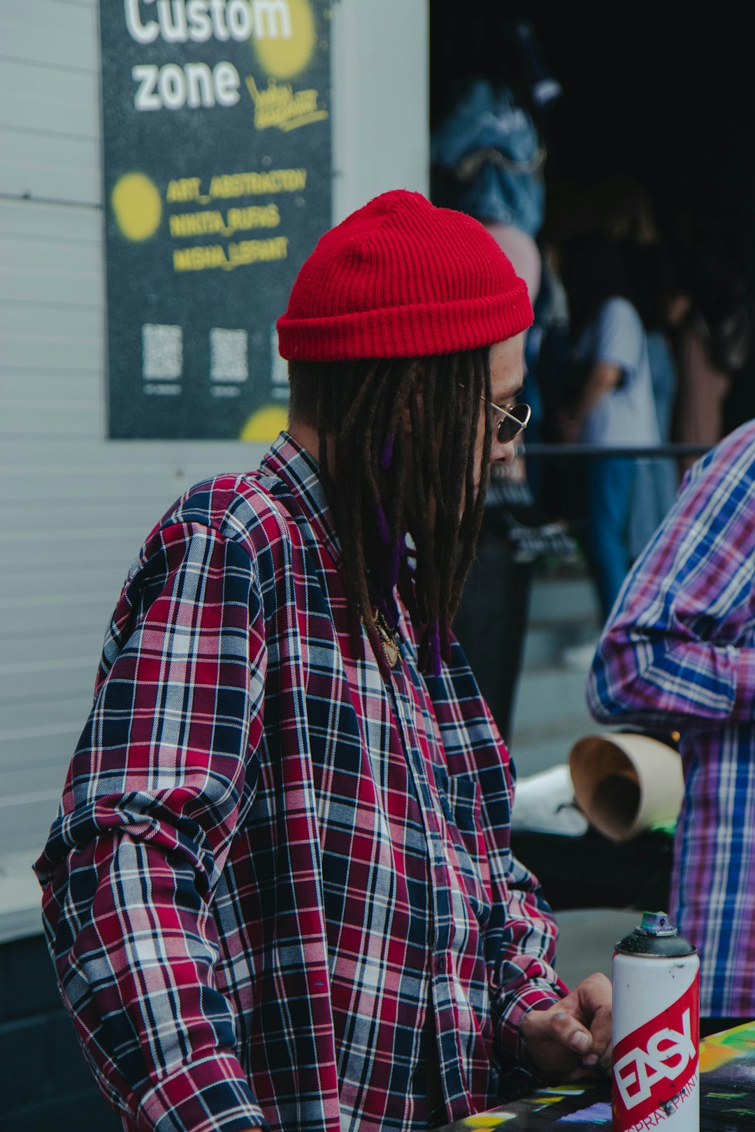 man in red knit cap and plaid dress shirt