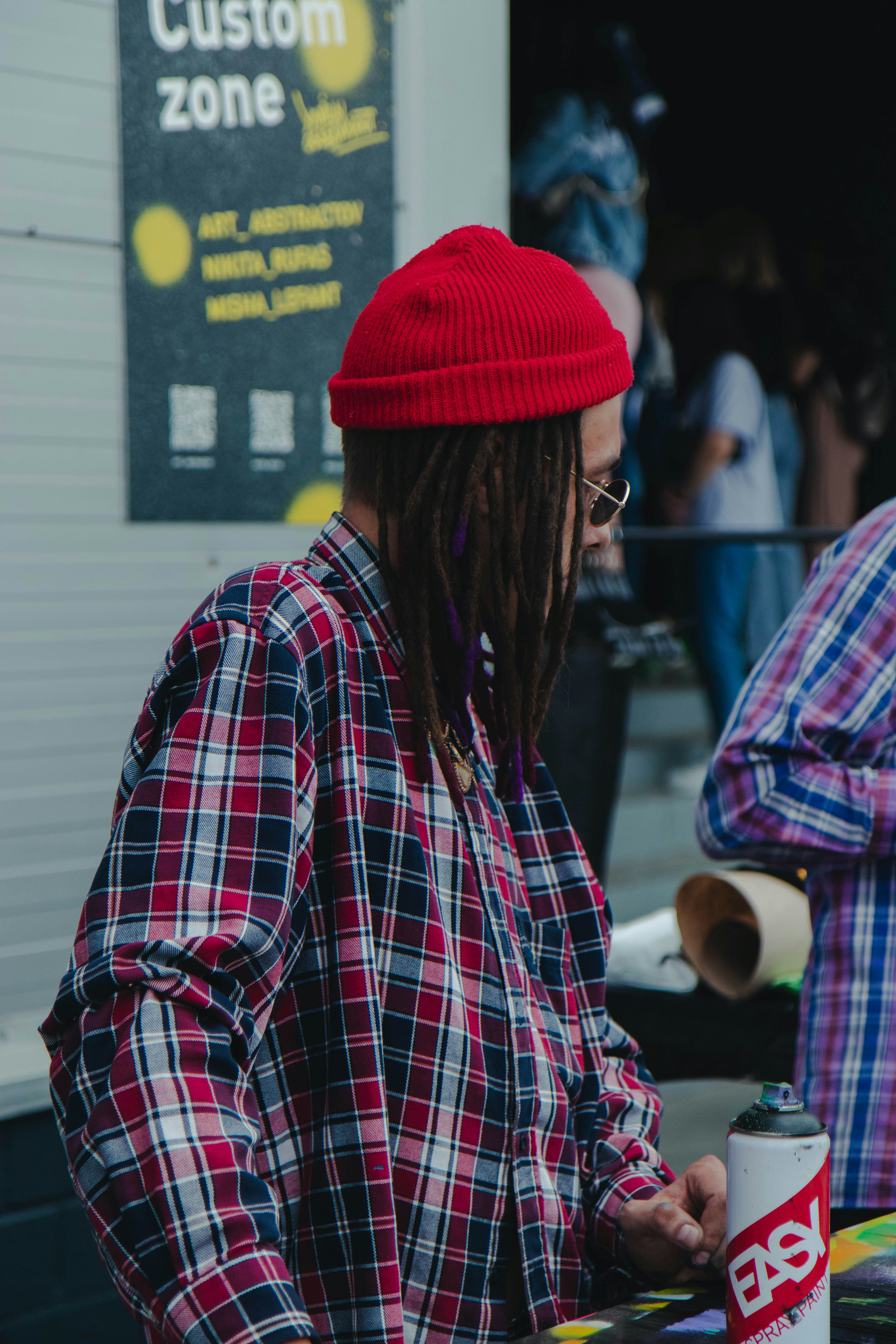 man in red knit cap and plaid dress shirt