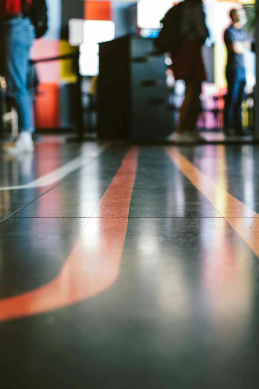 people walking on blue and orange floor tiles