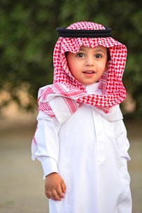 boy in white button up shirt wearing red and white plaid scarf