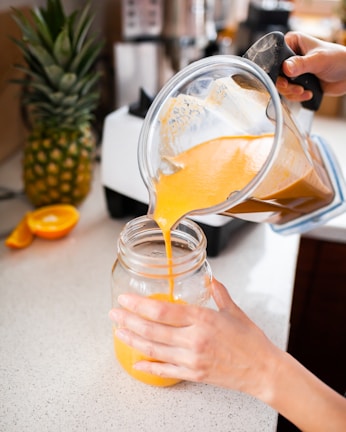 Close-up of hands preparing a nutritious smoothie with fresh fruits.